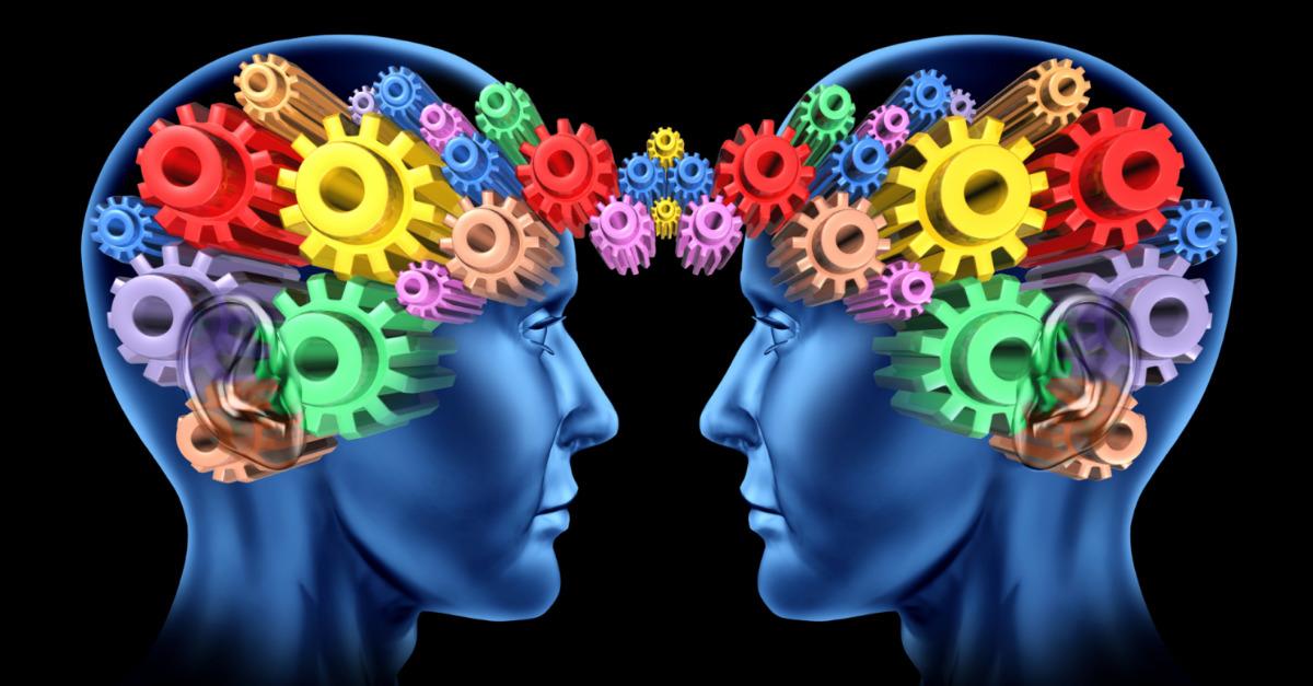 Imagem em desenho, com duas cabeças de frente uma para outra. De ambas saem engrenagems coloridas que se unem, simbolizando o poder da comunicação positiva para a colaboração.